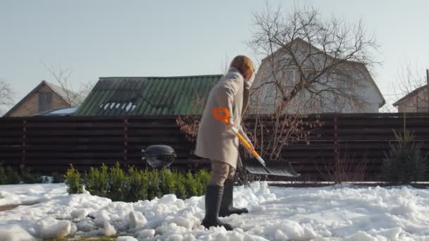Mujer limpia nieve con pala — Vídeos de Stock