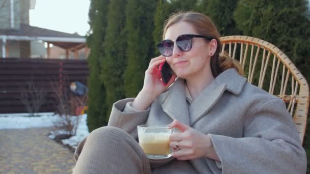 Kobieta rozmawiająca przez telefon z kawą — Wideo stockowe