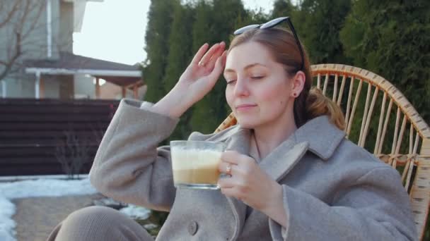 Vrouw op schommelstoel drinken koffie — Stockvideo