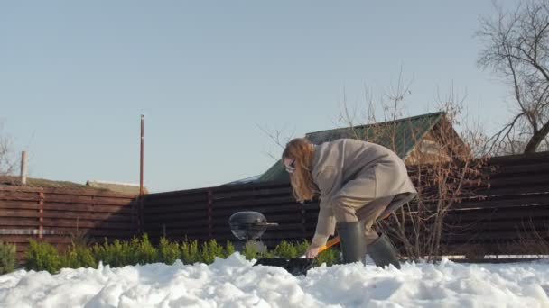 Mujer limpia nieve en el patio — Vídeos de Stock