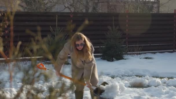 Joven mujer paleando nieve — Vídeos de Stock