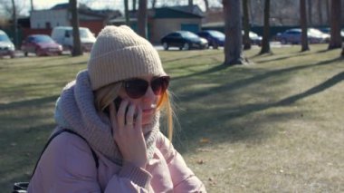 Parkta telefonla konuşan bir kadın.