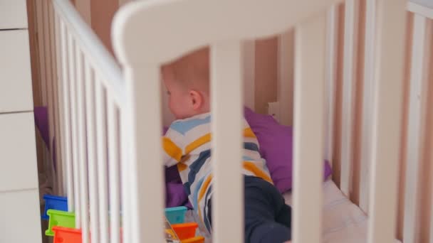 Niño jugando coches en la cama — Vídeos de Stock