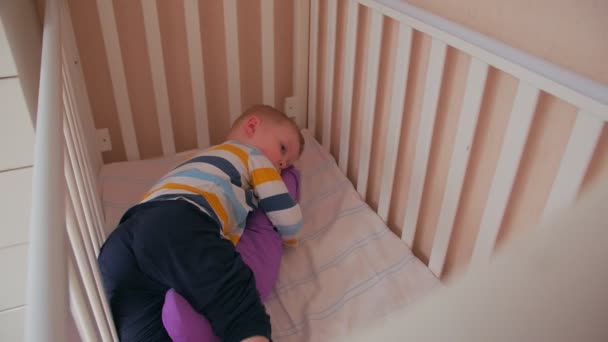 Niño jugando coche en la cama — Vídeo de stock