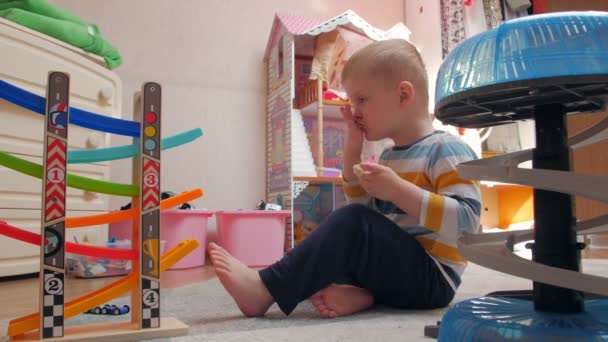 Mały chłopiec grać i żuć kanapkę — Wideo stockowe