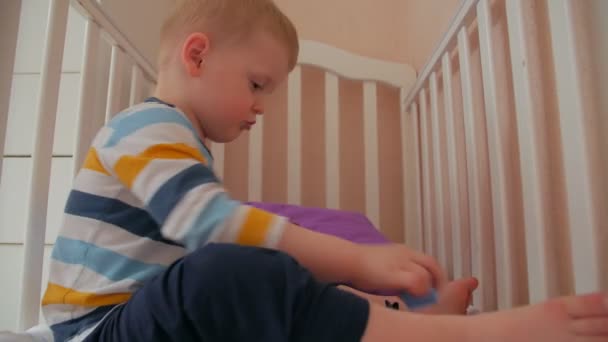 Menino jogar brinquedos na cama — Vídeo de Stock