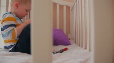 Çocuk beşiğinde arabalarla oynuyor.