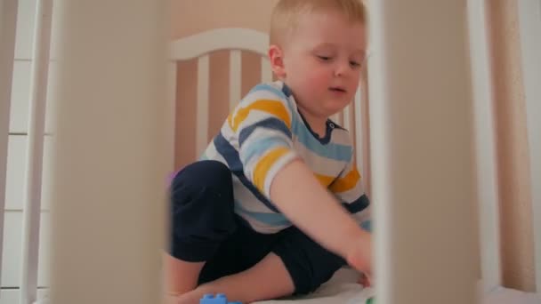 Boy Playing Cars In Crib — Stockvideo