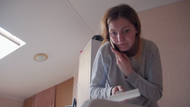 Женщина разговаривает по телефону и рисует — стоковое видео