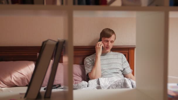 Man i sängen med telefon tid förflutit — Stockvideo