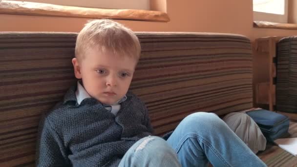 Μικρό αγόρι κάθεται στον καναπέ — Αρχείο Βίντεο
