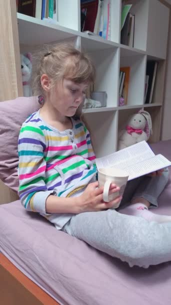 Menina lendo um livro e bebendo chá — Vídeo de Stock