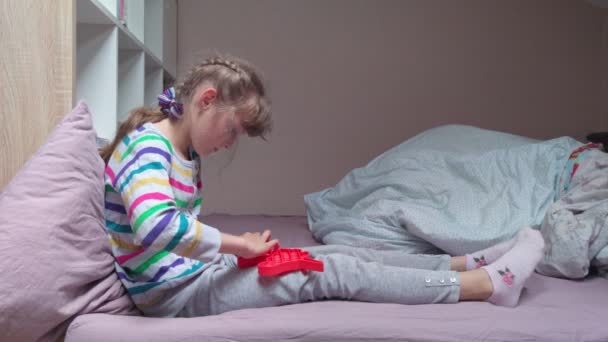 Meisje met pop het speelgoed op het bed — Stockvideo