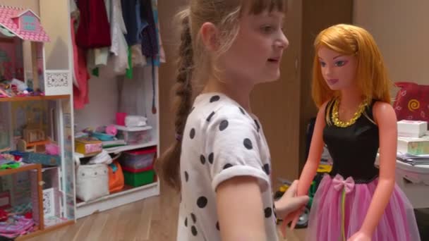 Девушка одевает куклу — стоковое видео