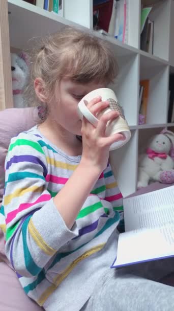 Chica bebiendo té con un libro — Vídeo de stock