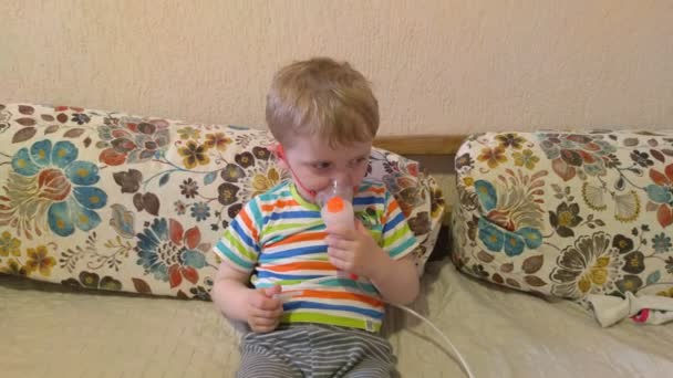 Маленький мальчик дышит ингалятором — стоковое видео