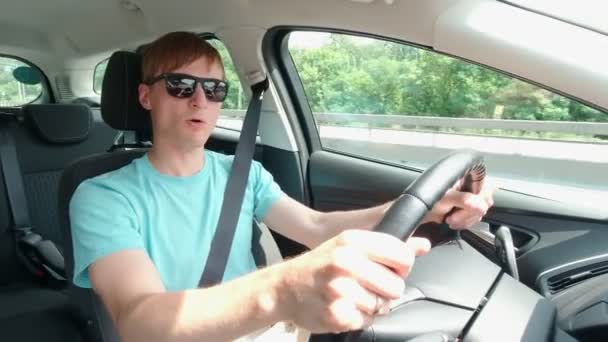 Щасливий чоловік співає в машині — стокове відео
