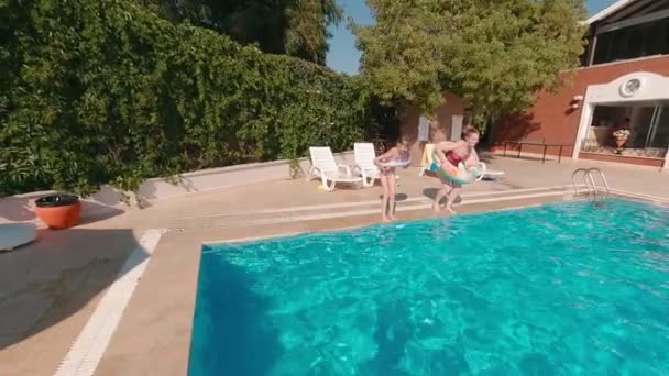 Mulher e menina pulando para a piscina — Vídeo de Stock