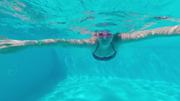 Kvinnen svømmer under vann i bassenget. – stockvideo