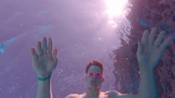 En mann svømmer bort under vann. – stockvideo