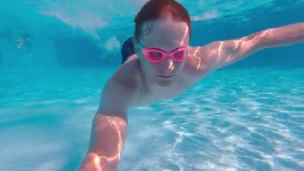 Mand svømmer i bunden af poolen – Stock-video
