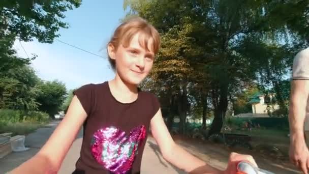 女孩骑着一辆自行车走在街上 — 图库视频影像