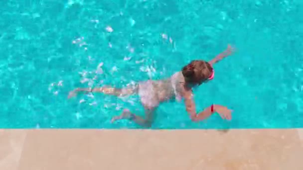 Dziewczyna w basenie uczy się pływać — Wideo stockowe