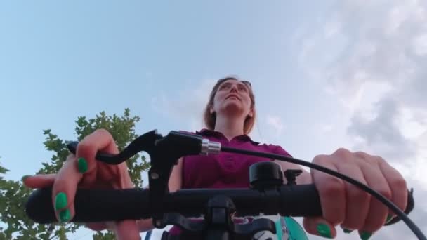 Vrouw paardrijden scooter in park — Stockvideo