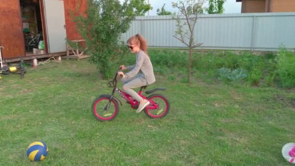 Девочка на велосипеде в заднем дворе — стоковое видео
