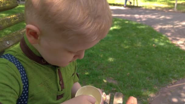Niño comiendo helado con una cuchara — Vídeo de stock