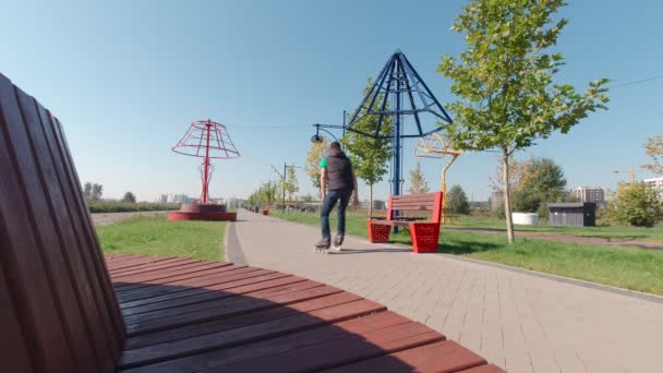 Muž na kolečkových bruslích vyjížďky v parku — Stock video