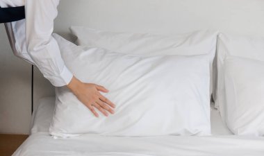 Otel odasının hizmetçileri yatak yapıyor, oda hizmetçisi kadın otel odasında yatak yapıyor.