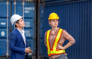Mühendis ve işçi ekibi konteynırları kargo, lojistik ve takım çalışması konseptinden kontrol ediyor.