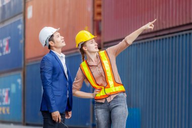 Mühendis ve işçi ekibi konteynırları kargo, lojistik ve takım çalışması konseptinden kontrol ediyor.