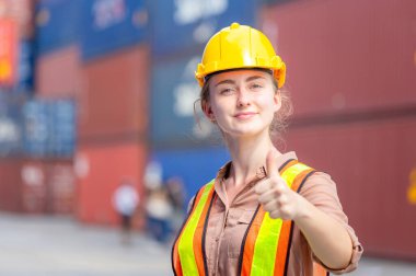 Gülümseyen neşeli bayan mühendis başarı işareti olarak başparmağını kaldırdı.