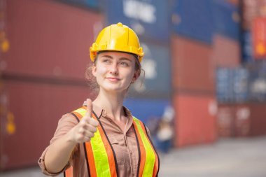 Gülümseyen ve gökyüzüne bakan neşeli kadın mühendis başarı işareti olarak başparmaklarını kaldırdı.