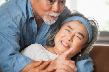 Oturma odasında kucaklaşan mutlu Asyalı çiftin portresini kapat.