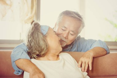 Oturma odasında kucaklaşan mutlu Asyalı çiftin yakın portresi. Ev kavramında yaşlı çift.