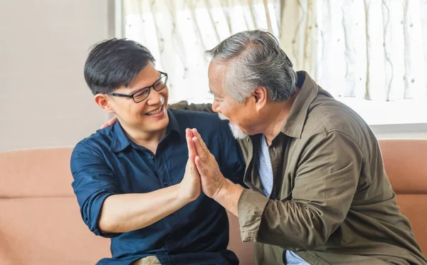 Cheerful senior asian father and middle aged son in living room, Happiness Asian family concepts