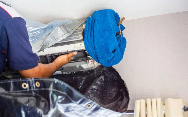 Close up of Air Conditioning Repair, repairman checking and cleaning a room air conditioner system