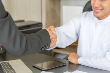 Arap Ortadoğulu işadamı ve iş kadını el sıkışır ve toplantıyı bitirir.