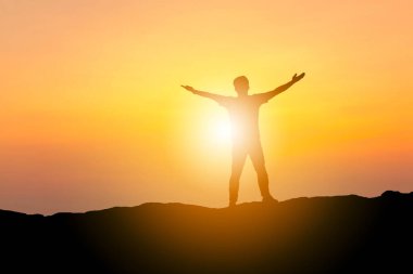 Kırpma yolu ile İnsanoğlunun silueti başarıyı kutluyor taş bir akşam gökyüzünde mutluluk gün batımı / gündoğumu arka plan, spor ve aktif yaşam konsepti.
