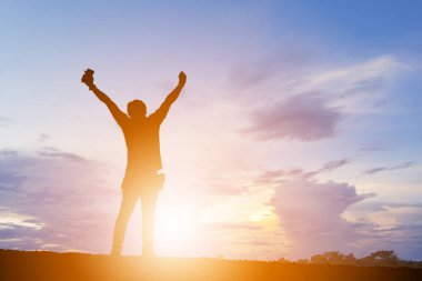 Günbatımının / gündoğumunun, akşam gökyüzünün arka planının, mutluluğun ve aktif hayatın tadını çıkaran silueti..