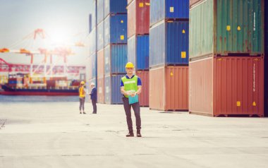 Kargo, lojistik konsept konteynır kutuları yükleme hard hat ve güvenlik yelek kontrol mühendis ve ustabaşı ekibi