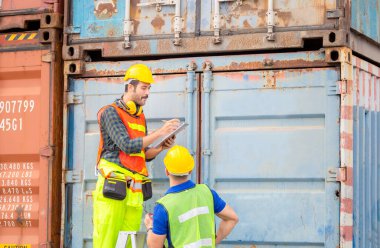 Mühendis ve işçi ekibi konteynırları kargo, mutluluk ve ekip çalışması konseptinden kontrol ediyor.