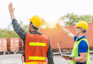 Ekip çalışması konsepti, mühendis ve ustabaşı ekip kargodan çıkan konteynırları kontrol ediyor.