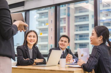 Başarı ve takım çalışması konsepti, genç iş adamlarından oluşan bir grup ofiste toplanıyor.