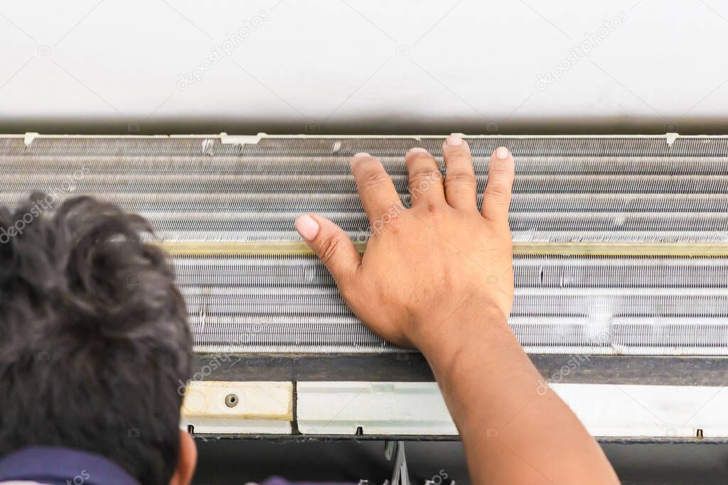 Air Conditioning Repair, Repairman fixing air conditioning system, Male technician service for repair and maintenance of air conditioners. Technician man using hand checking temperature