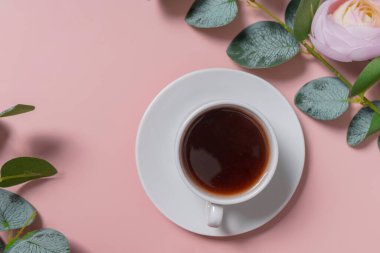 Beyaz bir fincan üzerinde küçük beyaz bir kahve fincanı. Espresso. Düz çizgi. Yukarıdan manzara. Çiçekli yumuşak pembe arka plan. kopyalama alanı