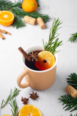 Baharatlı kırmızı şarap. Kahverengi bir kupada. köknar dalları ve mandallarıyla hafif bir arkaplanda